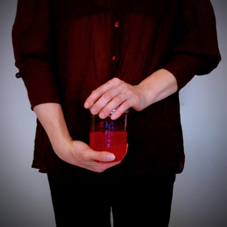 woman holding a glass of blood