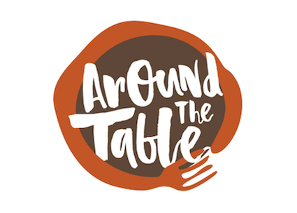 Image of a brick-coloured fork wrapped in a circle, like a pair of arms hugging the text in brown on the inside, Around the Table