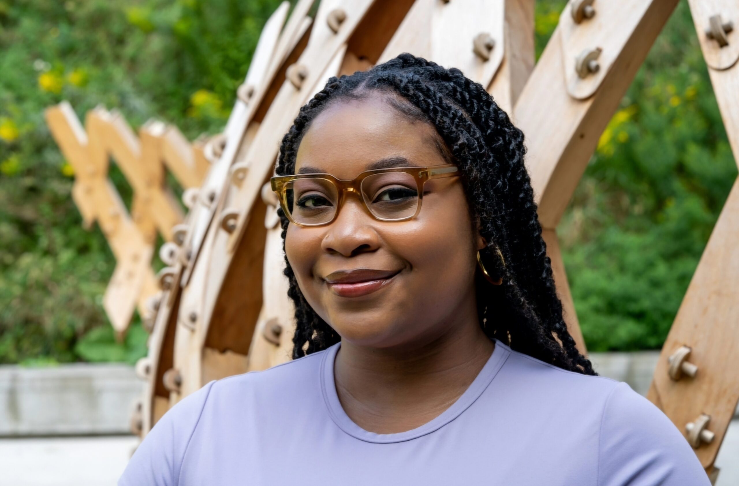 A photo of Terese Mason Pierre from the shoulders up. She is a Black woman with her hair in braids wearing caramel-coloured glasses and a lavender-coloured shirt.